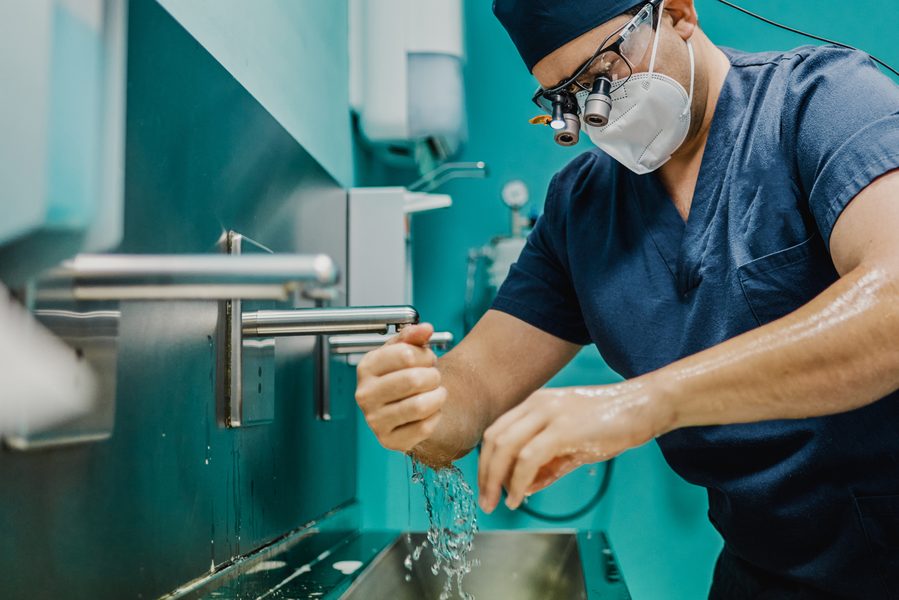 Surgeon washing hands in a clinical environment